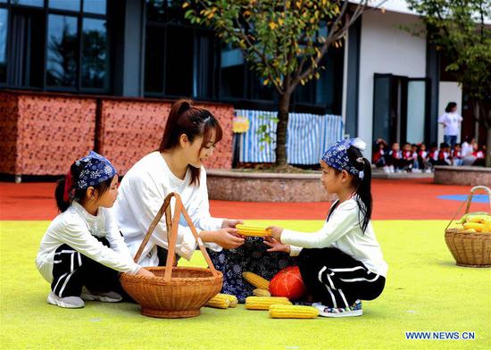 A teacher teaches children to recognise crops during an event held ahead of farmers' harvest festival in Changxing, east China's Zhejiang Province, Sept. 21, 2020. The third Chinese farmers' harvest festival falls on Sept. 22, 2020. (Xinhua/Xu Yu)