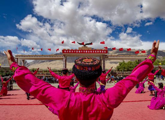 Performers dance during the Dragon Boat Festival at an intangible cultural heritage exhibition park in Taxkorgan Tajik Autonomous County, northwest China's Xinjiang Uygur Autonomous Region, June 25, 2020. (Xinhua/Hu Huhu)