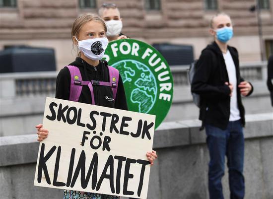 Greta Thunberg holds a poster reading “School strike for Climate” on Friday in front of the Swedish Parliament.