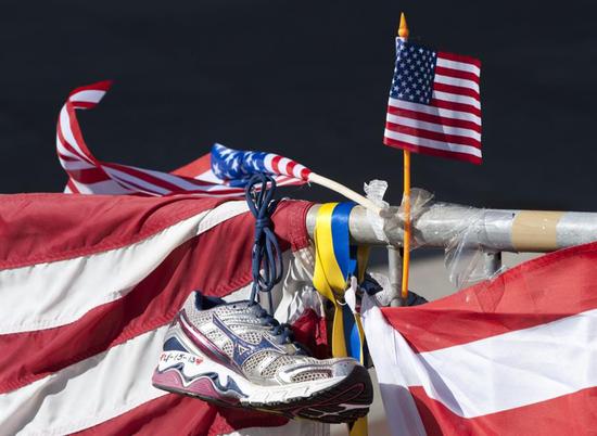 In this file photo taken on April 18, 2013 a running shoe and US flag are part of a memorial on the Boston Marathon route in Boston. A US appeals court overturned the death penalty for Boston Marathon bomber Dzhokhar Tsarnaev on July 31 and ordered a lower court to hold new sentencing hearings.