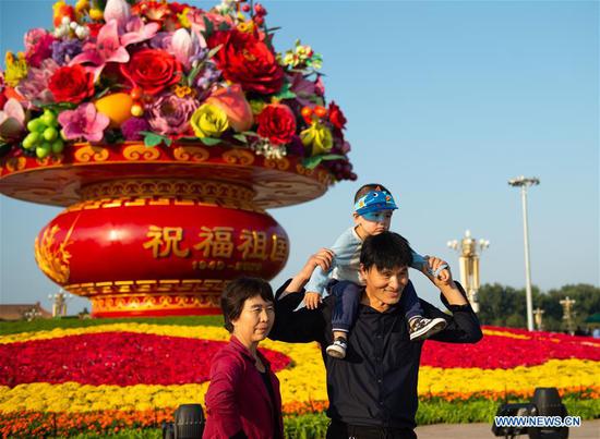 Tourists pose for photos in front of a 