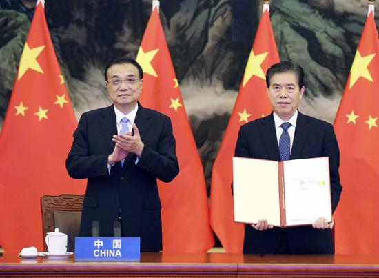 Chinese Premier Li Keqiang attends the signing ceremony of the Regional Comprehensive Economic Partnership (RCEP) agreement after the fourth RCEP Summit, which is held via video link, at the Great Hall of the People in Beijing, capital of China, Nov. 15, 2020. Chinese Commerce Minister Zhong Shan signed the agreement on behalf of China. (Xinhua/Liu Weibing)