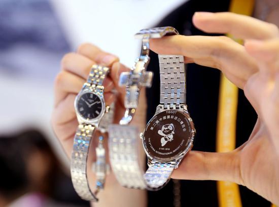 A staff member shows a limited-edition Swiss watch at the Lifestyles exhibition area during the second China International Import Expo (CIIE) in Shanghai, east China, Nov. 6, 2019. (Xinhua/Liu Ying)