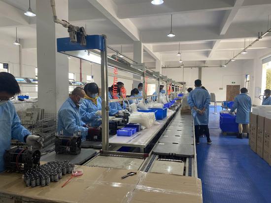 File photo taken on April 15, 2021 shows staff members working on the production line at Zhengzhou Olive Electronic Technology Co., Ltd. in Zhengzhou, capital of central China's Henan Province. (Xinhua)