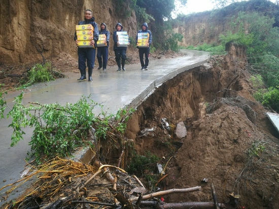 A "task force" formed by staff members of the Mugou station delivers relief supplies for stranded passengers of the train K31 in central China's Henan Province, July 21, 2021. (Xinhua)