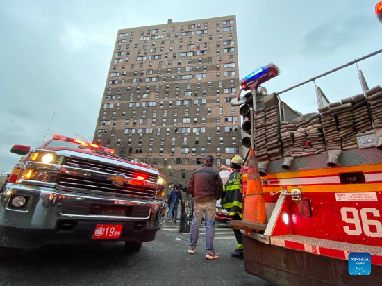 People are seen in front of the apartment building in Bronx, New York, the United States, on Jan. 9, 2022. At least 19 people, including nine children, lost their lives in a major fire in New York City on Sunday, various U.S. media outlets reported. (Photo by Michael Nagle/Xinhua)