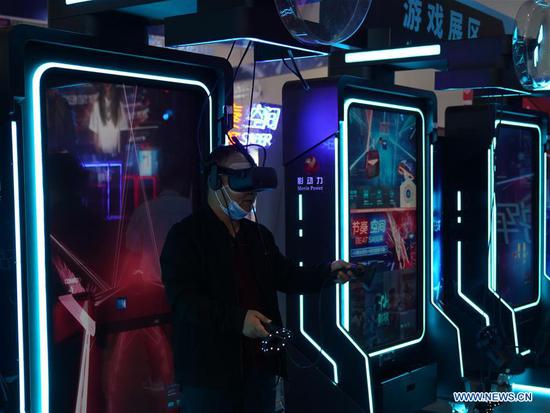 A visitor plays games based on VR (Virtual Reality) technology during the 2020 World Conference on VR Industry in Nanchang City, east China's Jiangxi Province, Oct. 19, 2020. The online summit of 2020 World Conference on VR Industry kicked off Monday in Nanchang. (Xinhua/Hu Chenhuan)