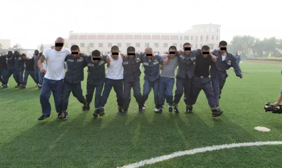 Inmates do exercise on the playground.