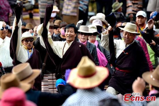 People perform a Guozhuang dance at a park near the Potala Palace in Lhasa, Southwest China’s Tibet Autonomous Region, Oct. 19, 2016. As one of the three major Tibetan folk dances, the Guozhuang dance involves 