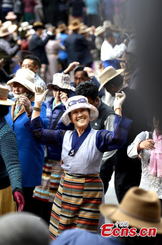 People perform a Guozhuang dance at a park near the Potala Palace in Lhasa, Southwest China’s Tibet Autonomous Region, Oct. 19, 2016. As one of the three major Tibetan folk dances, the Guozhuang dance involves 