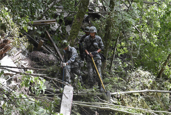 Soldiers search an area for anyone trapped after the earthquake in Jiuzhaigou County in Sichuan Province yesterday.