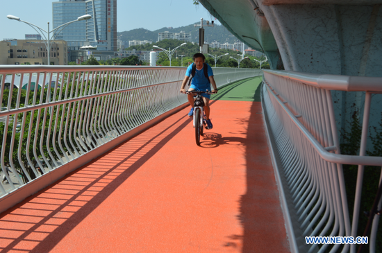 A citizen rides along an elevated bicycle path in Xiamen, southeast China's Fujian Province, Aug. 5, 2017. (Xinhuanet/Zhang Dan)