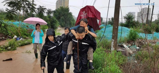 Police officers transfer stranded people after rainstorms hit Mentougou District in Beijing, capital of China, July 18, 2021. The Beijing Meteorological Observatory on Sunday morning issued an orange warning for rainstorms after the accumulated rainfall in some areas of the capital had exceeded 150 mm. (Xinhua)