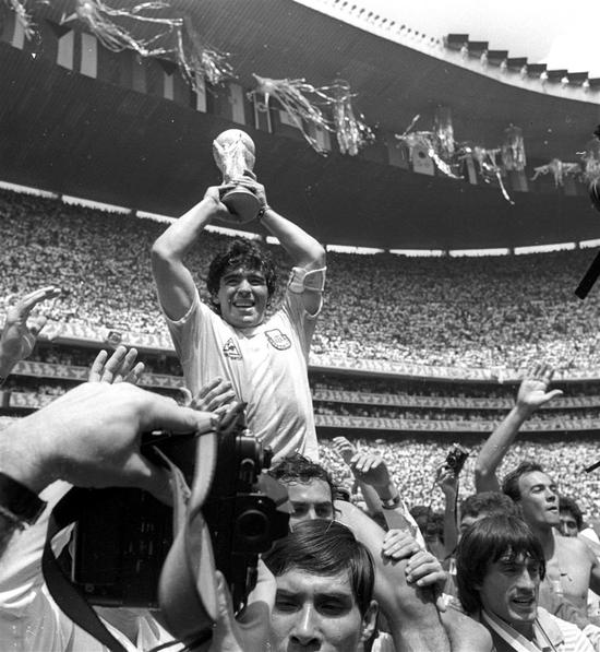 Argentine star Diego Maradona holds up the World Cup trophy as he is carried off the field after Argentina defeated West Germany 3-2 to win the World Cup soccer championship in Mexico City June 29, 1986.