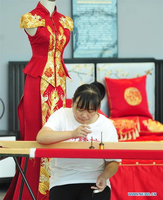 An embroider demonstrates embroidery skills at the exhibition area of the 8th China Taobao Village Summit Conference in Suning County, north China's Hebei Province, Sept. 26, 2020. The 8th China Taobao Village Summit Conference was held in Suning on Saturday. The Taobao Villages are rural e-commerce hubs that feature Alibaba's logistics, service and training to encourage farmers to engage in online sales of farm produce and local specialties. With 17 Taobao Villages and 9 Taobao Towns, Suning has a total of over 21,000 e-commerce online stores, achieving a yearly revenue of nearly 10 billion yuan (about 1.47 billion U.S. dollars). (Xinhua/Zhu Xudong)