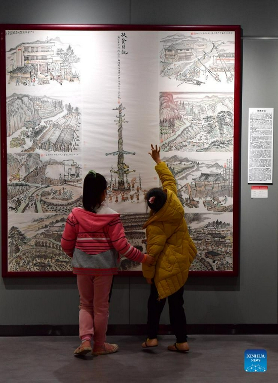 People visit the art exhibition of Wei Sancai at an art museum in Liuzhou City, south China's Guangxi Zhuang Autonomous Region, Dec. 5, 2021. An art exhibition of Wei Sancai, an art teacher, was unveiled on Friday in Liuzhou, displaying 100 art works on the theme of poverty alleviation and rural revitalization created by Wei during his tenure as a poverty alleviation official in Damiao Mountain. When he was assigned to Gaoqiang Village in Rongshui Miao Autonomous County of Liuzhou, Wei recorded the changes of the village with his paintings. In his spare time, he also took advantages of his profession to offer art classes for local children, providing them an access to the knowledge of arts. (Xinhua/Huang Xiaobang) 