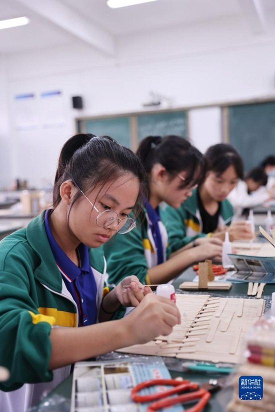 Photo shows students from Wanning Middle School, south China’s Hainan, taking part in an arts and crafts class on November 24. Extra-curricular activities are tailored to childrens’ age and interests, with students having the opportunity to paticipate in arts and crafts, caligraphy and photography, among others. It is hoped that increased access to extra-curricular activities will help promote the all-round development of children. (Photo by Zhang Liyun/Xinhua)
