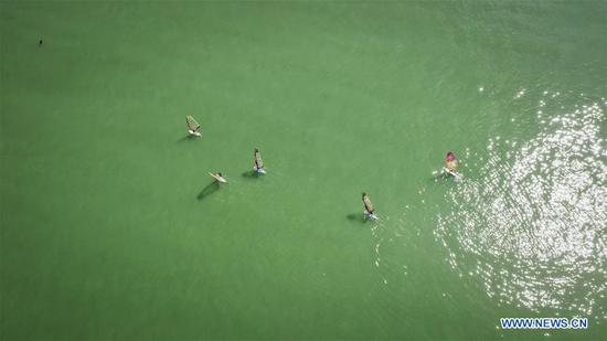 Aerial photo taken on Sept. 28, 2020 shows people taking sailing boats on the sea in Rizhao City, east China's Shandong Province. China is set to welcome eight days of national holiday this year as the Mid-Autumn Festival coincides with the country's National Day. (Xinhua/Fan Changguo)