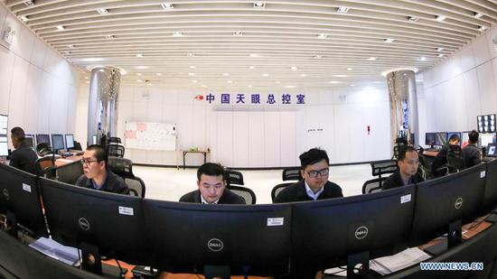 Staff members work at the control room of China's Five-hundred-meter Aperture Spherical radio Telescope (FAST) in southwest China's Guizhou Province, March 27, 2021. FAST has identified over 300 pulsars so far. Located in a naturally deep and round karst depression in southwest China's Guizhou Province, it officially began operating on Jan. 11, 2020. (Xinhua/Ou Dongqu)