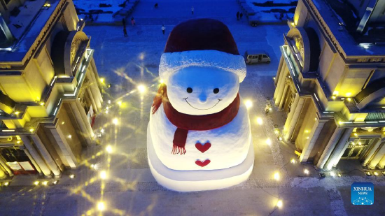 Aerial photo taken on Jan. 9, 2022 shows a huge snowman on the riverbank of Songhua River in Harbin, capital of northeast China's Heilongjiang Province. The giant snowman is about 18 meters tall and 13 meters wide, using more than 2,000 cubic meters of snow. (Xinhua/Wang Jianwei)