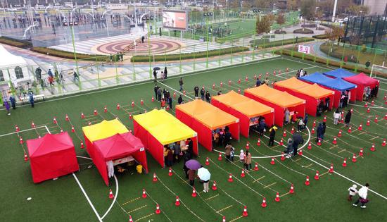 In this aerial photo taken on Nov. 21, 2020, residents line up waiting to take nucleic acid tests in the Binhai New Area in north China's Tianjin Municipality.(Xinhua/Zhao Zishuo)