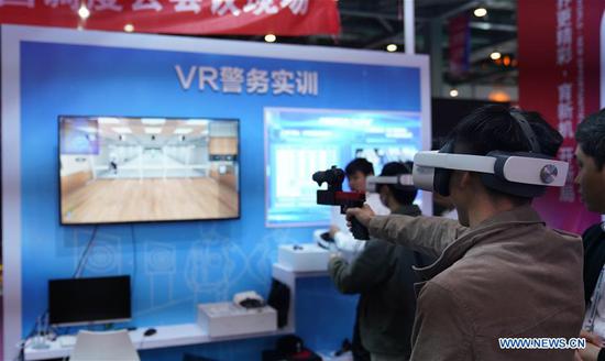 Visitors experience police training based on VR (Virtual Reality) technology during the 2020 World Conference on VR Industry in Nanchang City, east China's Jiangxi Province, Oct. 19, 2020. The online summit of 2020 World Conference on VR Industry kicked off Monday in Nanchang. (Xinhua/Hu Chenhuan)