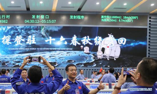 Technicians celebrate the successful launch of the Chang'e-5 spacecraft at the Wenchang Spacecraft Launch Site in south China's Hainan Province, Nov. 24, 2020. China on Tuesday launched a spacecraft to collect and return samples from the moon, the country's first attempt to retrieve samples from an extraterrestrial body. (Xinhua/Jin Liwang)