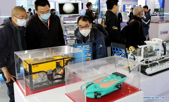 Visitors view exhibited robot models designed for underwater works during the 8th China (Shanghai) International Technology Fair (CSITF) in east China's Shanghai, April 15, 2021. The 8th CSITF kicked off on Thursday. With an exhibition area covering 35,000 square meters, this year's fair has 5 different sections and has attracted over 1,000 exhibitors. (Xinhua/Fang Zhe)