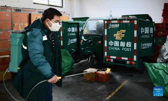 A staff member from a branch of China Post disinfects the warehouse in Xi'an, capital of northwest China's Shaanxi Province, Jan. 13, 2022. Postal and express delivery services in Xi'an have been gradually resumed in an orderly manner with strengthened epidemic prevention measures amid the latest resurgence. (Photo by Zou Jingyi/Xinhua)