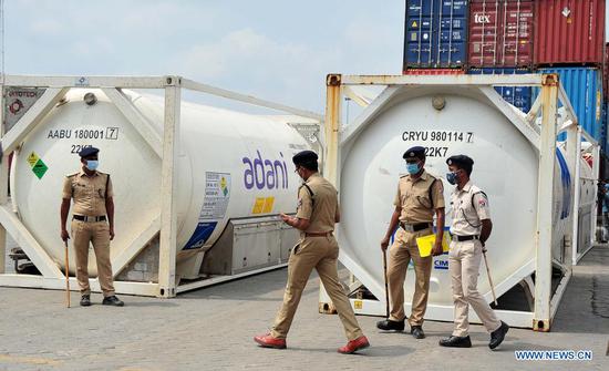 Police stand guard near liquid medical oxygen (LMO) containers each carrying 20 tons of LMO after an Oxygen Express arrived at a railway station in Bangalore, India, May 11, 2021. (Str/Xinhua)