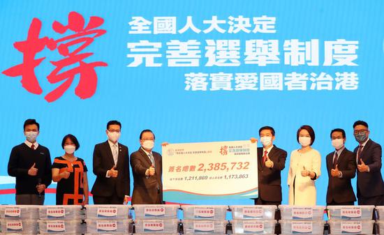 Tam Yiu-chung (4th L), one of the conveners, hands over a petition signed by over 2.38 million people in support of improving Hong Kong's electoral system to Luo Huining (4th R), director of the Liaison Office of the Central People's Government in the Hong Kong Special Administrative Region, in Hong Kong, south China, March 24, 2021. (Xinhua/Li Gang)