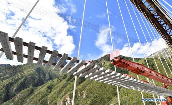 Engineering technicians lay railway tracks on a grand bridge over the Yarlung Zangbo River in Gyaca County, Shannan City, southwest China's Tibet Autonomous Region, Sept. 20, 2020. Track laying work was carried out here Sunday on a grand bridge of the railway linking regional capital Lhasa and Nyingchi. The 435-km Lhasa-Nyingchi railway, 75 percent of which is bridges and tunnels, has a designed speed of 160 km/h, and is expected to be completed and put into operation in 2021. (Xinhua/Chogo)