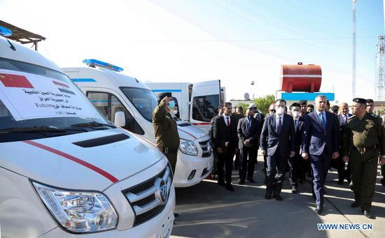 Chinese Ambassador to Iraq Zhang Tao (3rd R, Front) and Iraqi Interior Ministry's Senior Deputy Minister Hussein al-Awadi (2nd R, Front) inspect the donated ambulances in Baghdad, Iraq, on Jan. 21, 2021. The Chinese Embassy in Iraq on Thursday delivered donation to Iraq, helping the Iraqi government confront the COVID-19 pandemic and improve the livelihood of Iraqi people. (Xinhua)