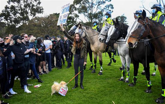 Protesters confront police at the Shrine of Remembrance in Melbourne, Australia, on Saturday, during an anti-lockdown rally against strict restrictions amid the coronavirus pandemic. Victoria state on Sunday extended a hard lockdown in its capital Melbourne until September 28. — AFP