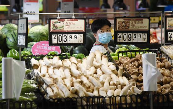 A consumer buys vegetables at a supermarket in Handan City, north China's Hebei Province, Aug. 10, 2020. (Photo by Hao Qunying/Xinhua)