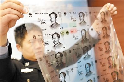 Police officers display half-made counterfeit bank notes at a press conference yesterday.
