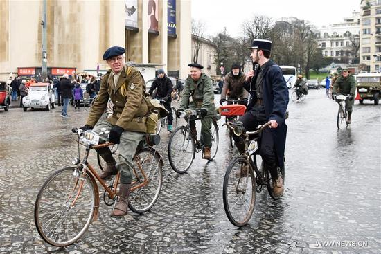 Cyclists ride vintage bikes past the Trocadero Square in Paris, France on Jan. 7, 2018. Hundreds of vintage cars, racing cars, jeeps, buses, motorcycles and bikes participated on Sunday in the 18th Paris Crossing of Classic Cars. (Xinhua/Chen Yichen)