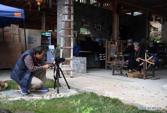 Folk culture researcher Liang Hanchang shoots a video of traditional weaving in Guyuepo village of Nanyang Township in Qingxiu District of Nanning, capital of south China's Guangxi Zhuang Autonomous Region, Jan. 4, 2018. In 2015, the local government started to promote folk art and custom projects with traditional folk houses which had long been idled, making the once conventional agricultural village a unique attraction to visitors. (Xinhua/Lu Boan)