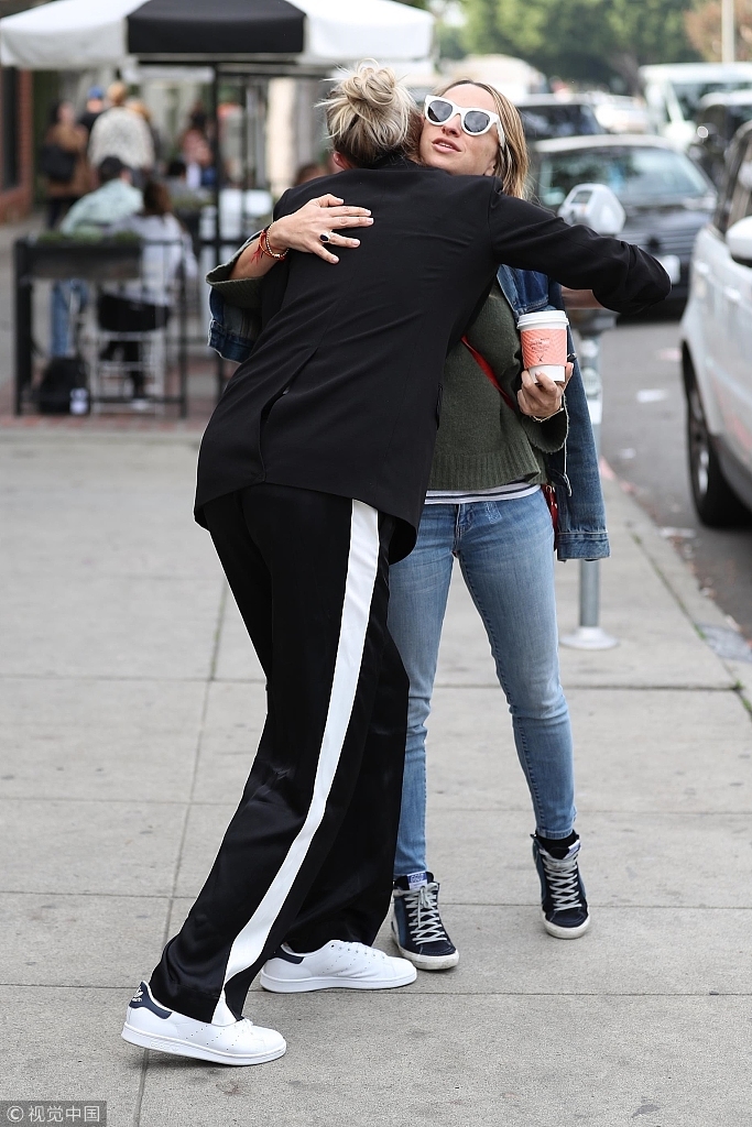 组图 卡莉 克劳斯叉腿俯身拥抱好友 酷帅黑衣秀大长腿拉风出街