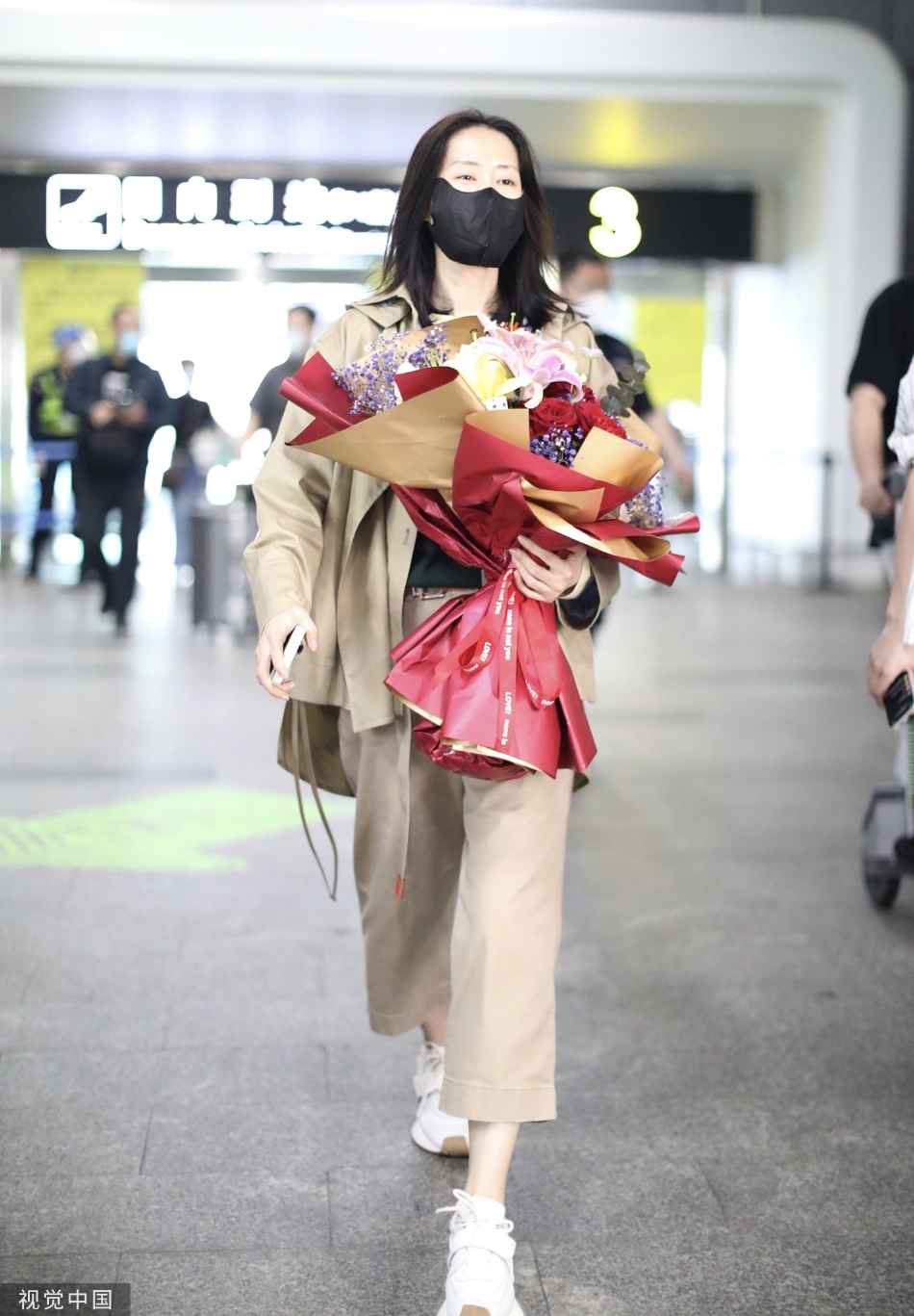 组图:刘敏涛着卡其色套装抵达长沙机场获粉丝赠花笑容满面第2张图片 组图:刘敏涛着卡其色套装抵达长沙机场获粉丝赠花笑容满面第2张图片