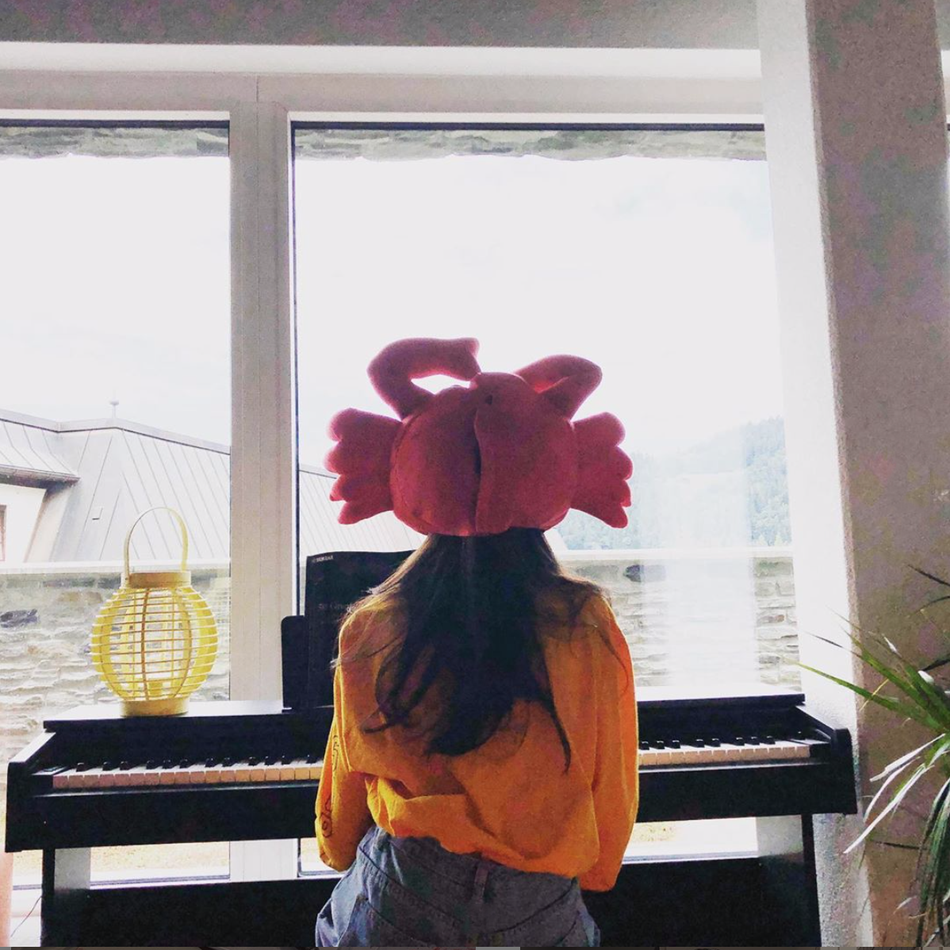 「奇趣网」李嫣长发披肩背影窈窕晒弹钢琴照 戴螃蟹头套显少女心