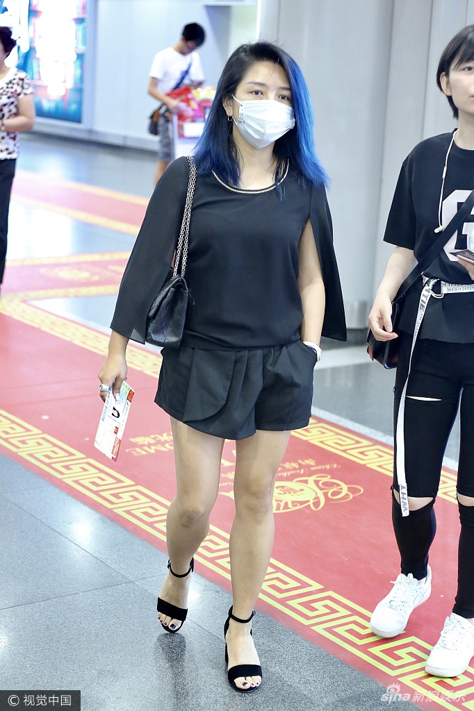 组图:何洁全黑LOOK现身口罩遮面 头靠助理肩头撒娇