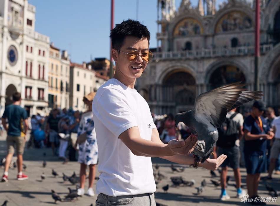 圣马可广场到了，这里有很多亲人的鸽子，王栎鑫抓了一把鸟食，就和它们玩了起来