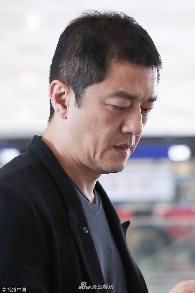 组图:李亚鹏西装配球鞋休闲帅气 低头皱眉看手机