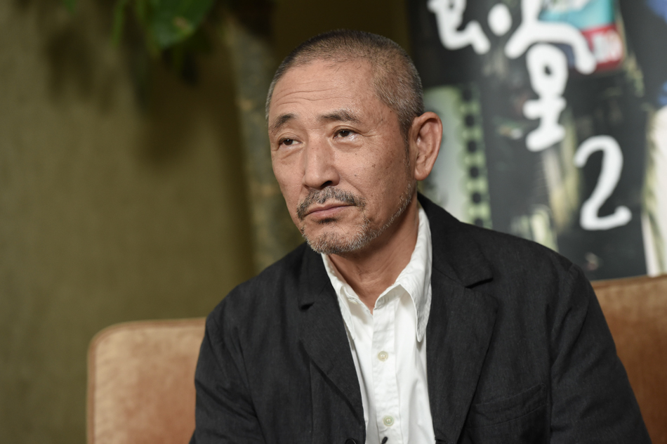 他穿着宽松舒适的布衣,不时露出一抹礼貌的浅笑,回答问题的话语不会