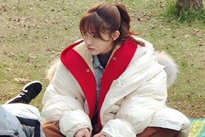 林允裹红白羽绒服坐草地姿势可爱