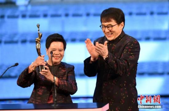　　4月15日晚，第37届香港电影金像奖颁奖典礼在香港文化中心大剧院举行，今年的专业精神奖由提供茶水阿姐杨蓉莲（左）获得，奖项颁奖嘉宾为成龙。中新社记者 谭达明 摄