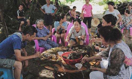 2014年端午，海南澄迈县，李美金老人和土龙村村民请剧组吃粽子。