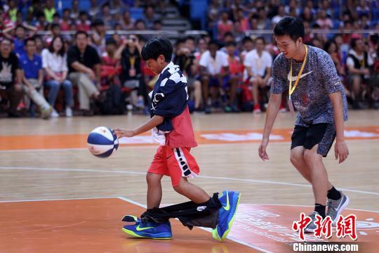 小球员穿上CBA球员的裤子和鞋子参加趣味投篮比赛。　泱波 摄