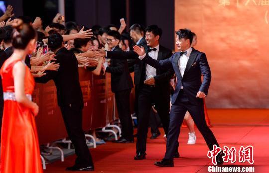 获奖嘉宾段奕宏、郭晓东在走红毯时与观众互动。 胡耀杰 摄